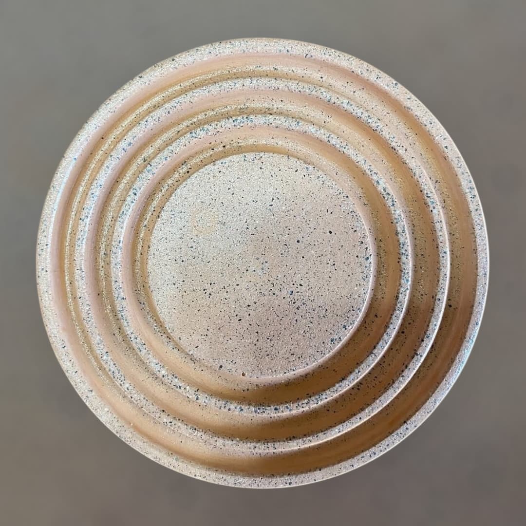 Portavasos Áurea de concreto en tono durazno con motas oscuras, visto desde arriba